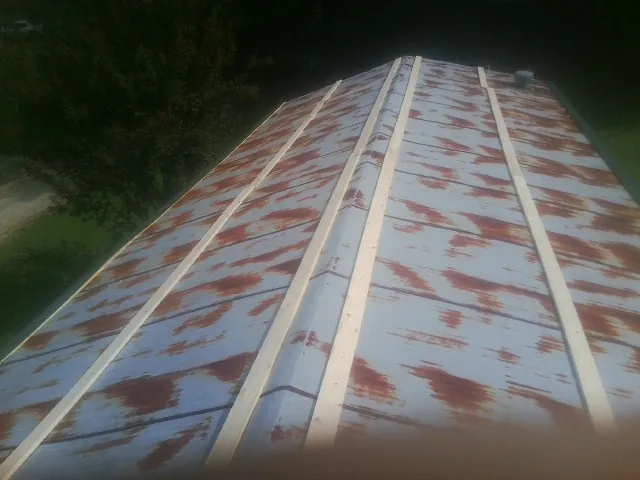 Rusted metal roof panels with new wood purlins before replacement — Storm Damage Roof Repair in Larkspur by Roofing Brothers